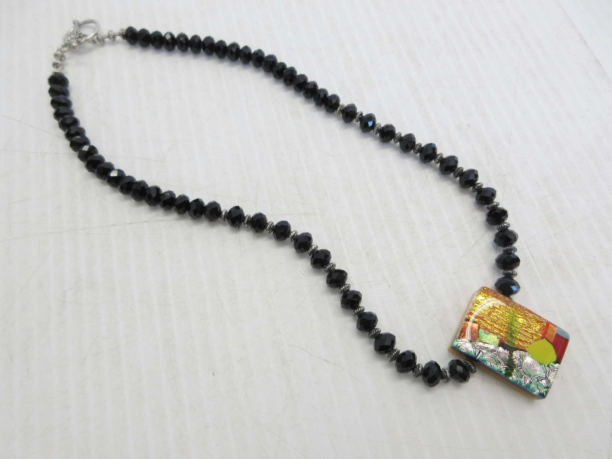 Albrecht Auctions Jet Black Glass Beads with a Stained Glass Piece in