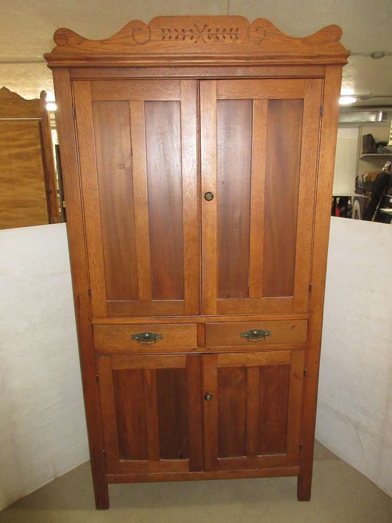 Antique Wood Cabinet with Two Latching Doors and Shelves on Top, Two Drawers in Center, Two Latching Doors on Bottom with One Shelf, and Two Pie Safe Style Holes on Each Side on Bottom Section