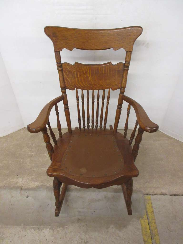 Older oak rocking chair with a brown pad, pad has some damage, 25"W x 36"H